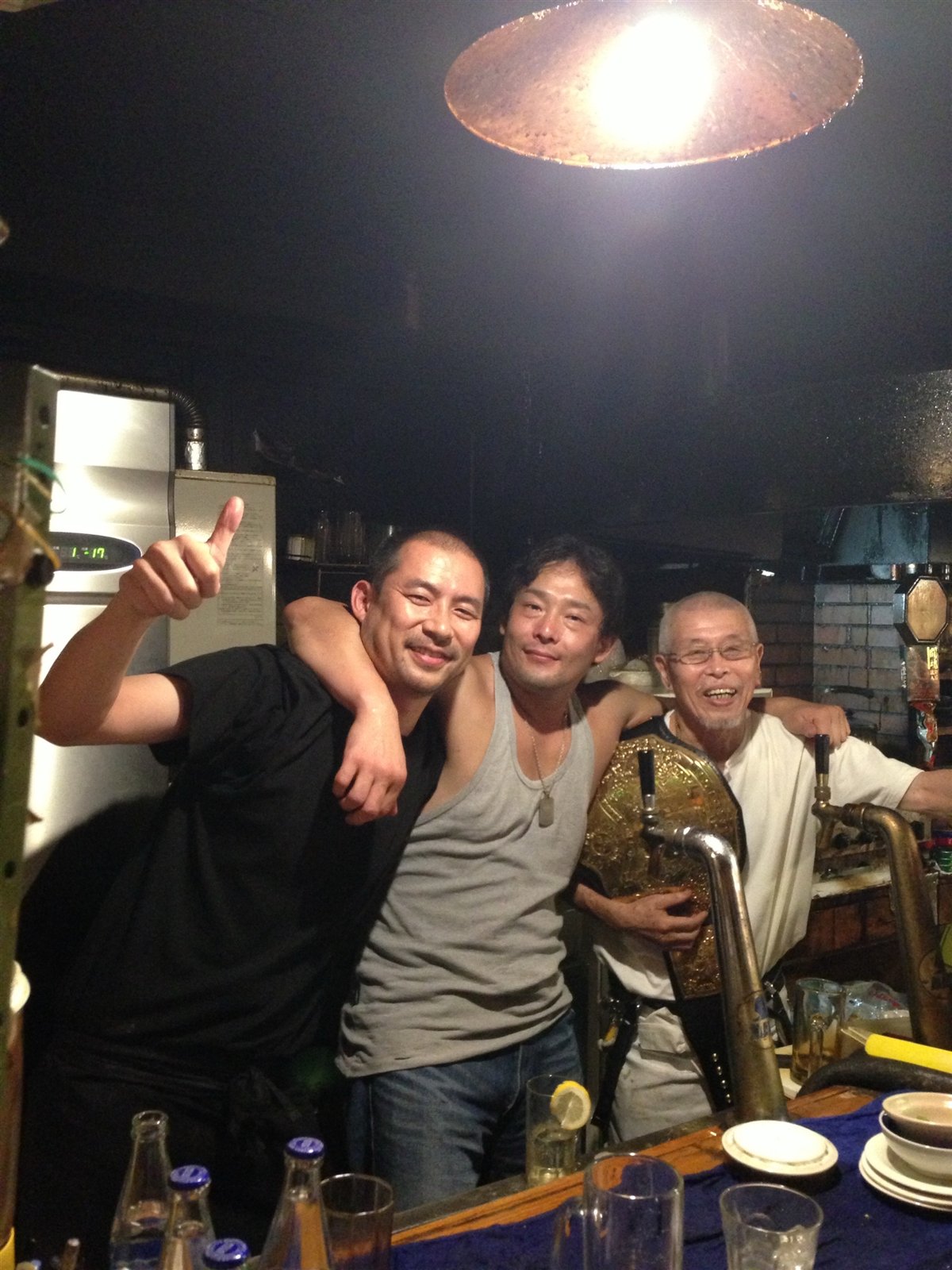 チャンピオンベルトを手にしたレスラーたちと村田マスター