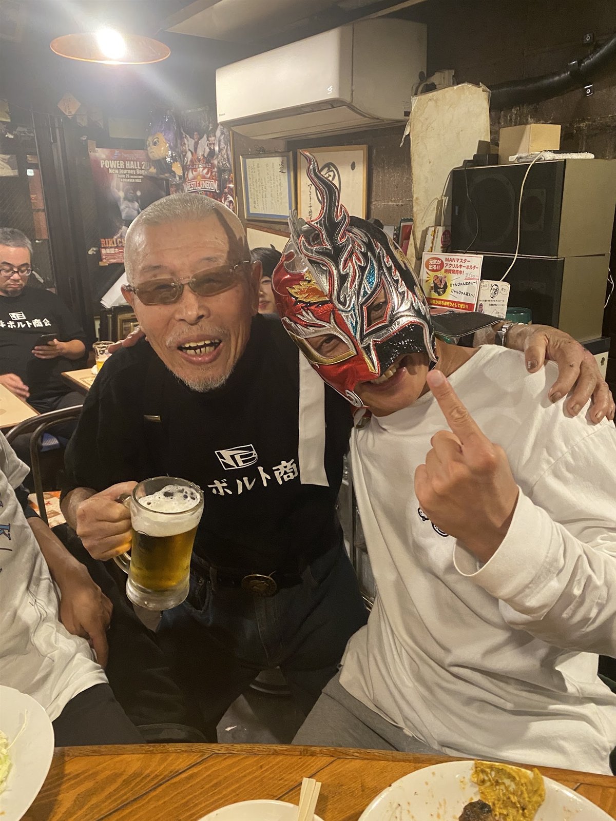 マスク姿のレスラーとビールを手にする村田マスター