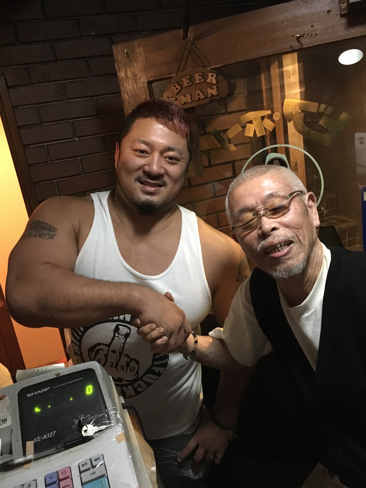 来店したレスラーと握手を交わす村田マスター