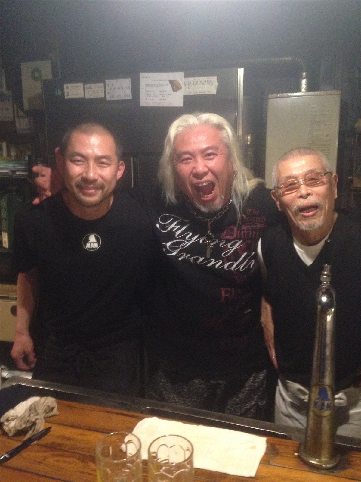 カウンターの内側で二人のレスラーと並ぶ村田マスター